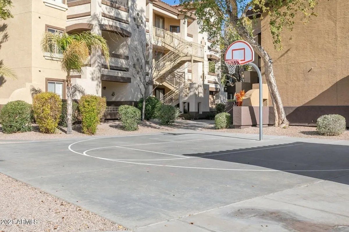 A dynamic outdoor basketball court with a hoop positioned against a backdrop of green landscaping and apartment buildings. The image captures the energetic, communal spirit of the property, emphasizing opportunities for friendly games, gatherings, and outdoor recreation.